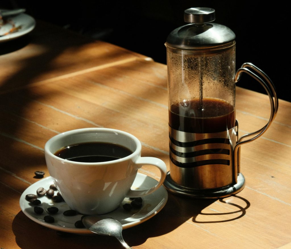 French Press mit Kaffeetasse auf einem Holztisch