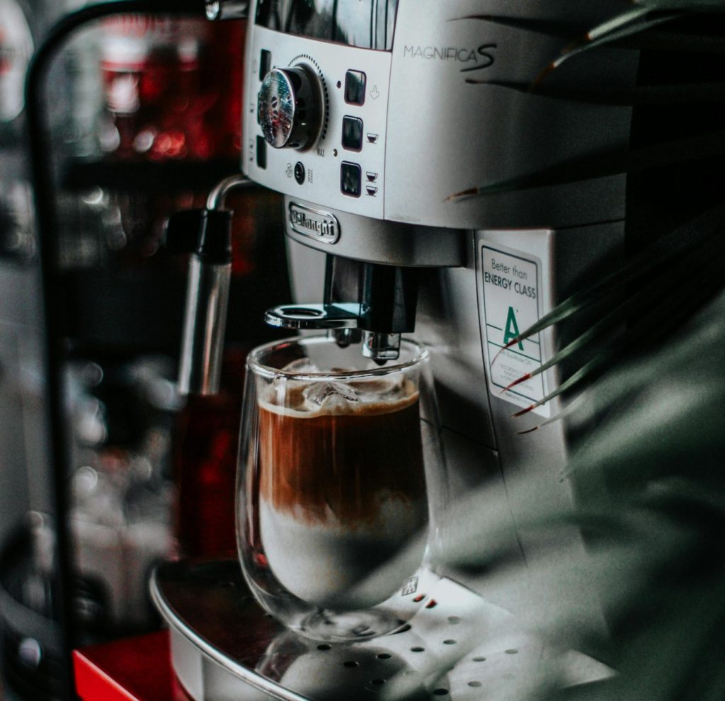 Ein Milchkaffee steht in einem Kaffeevollautomaten