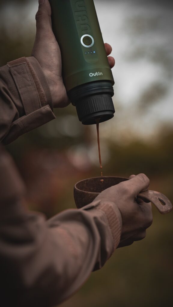 Outdoor Szene einer OutIn Nano, welche einen Espresso zubereitet.